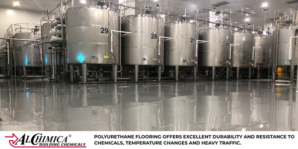 Polyurethane industrial flooring in a heavy-duty manufacturing facility with stainless steel tanks.
