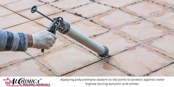 Worker applying polyurethane sealant to outdoor tile joints for building protection against autumn and winter weather in the UK